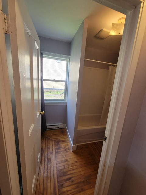 a small hallway with a closet and a window