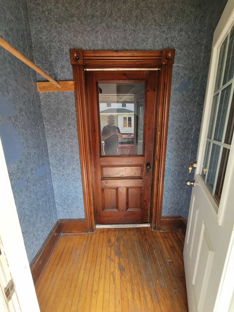 a person standing in a room with a wooden door