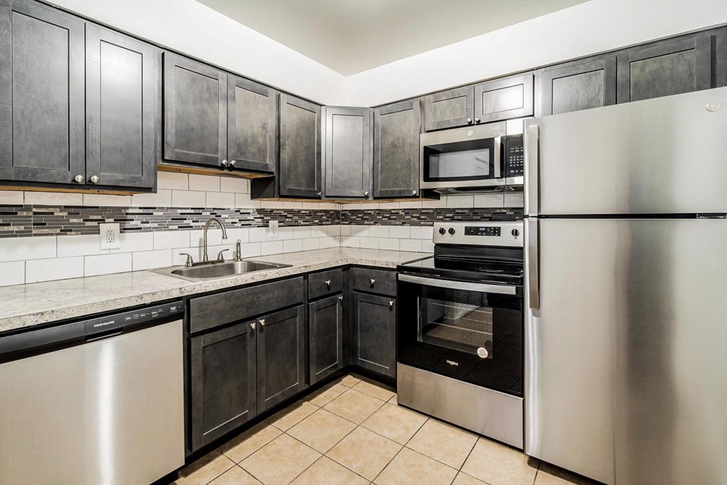 a kitchen with stainless steel appliances and black cabinets