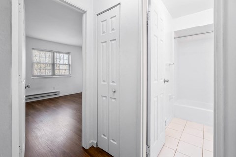 an empty bedroom with white closets and a wood floor