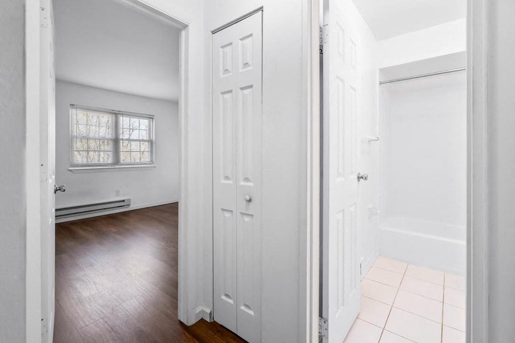 an empty bedroom with white closets and a wood floor
