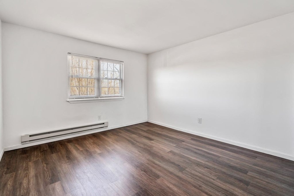 an empty living room with white walls and wood floors