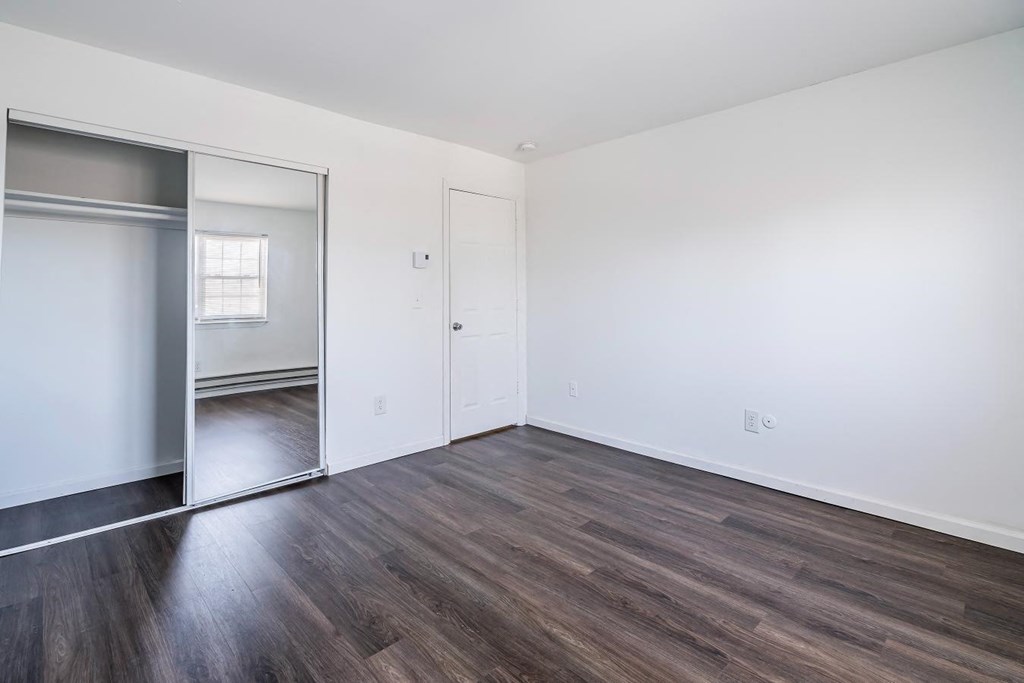 an empty living room with white walls and wood floors