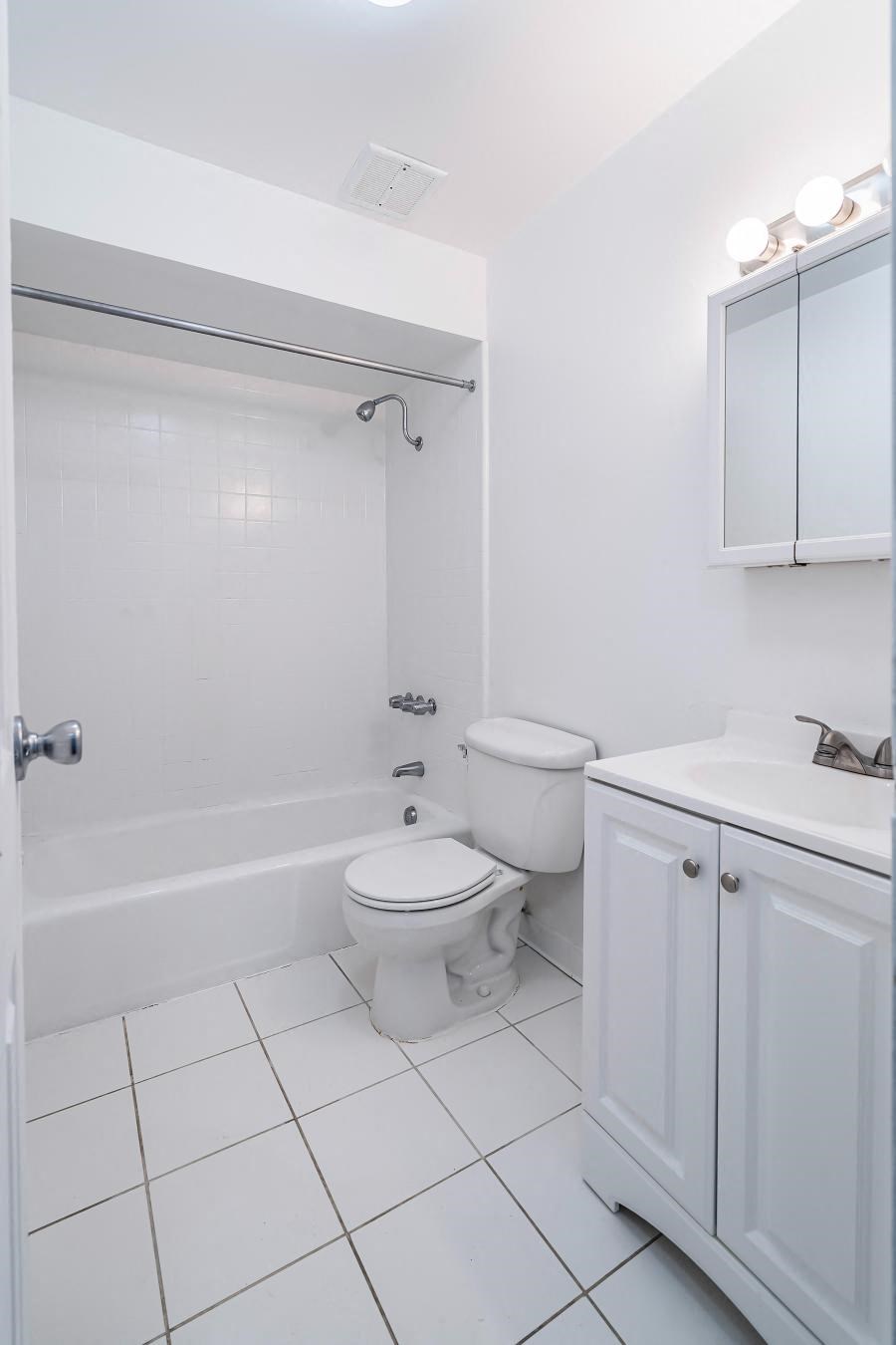 a white bathroom with a toilet and a sink