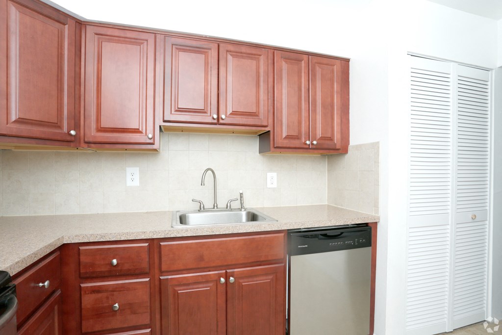 a kitchen with wooden cabinets and a sink and a dishwasher