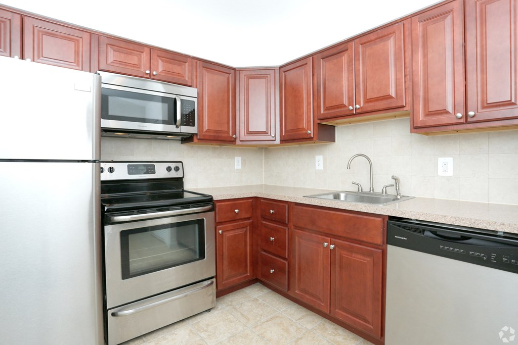 a kitchen with wooden cabinets and stainless steel appliances