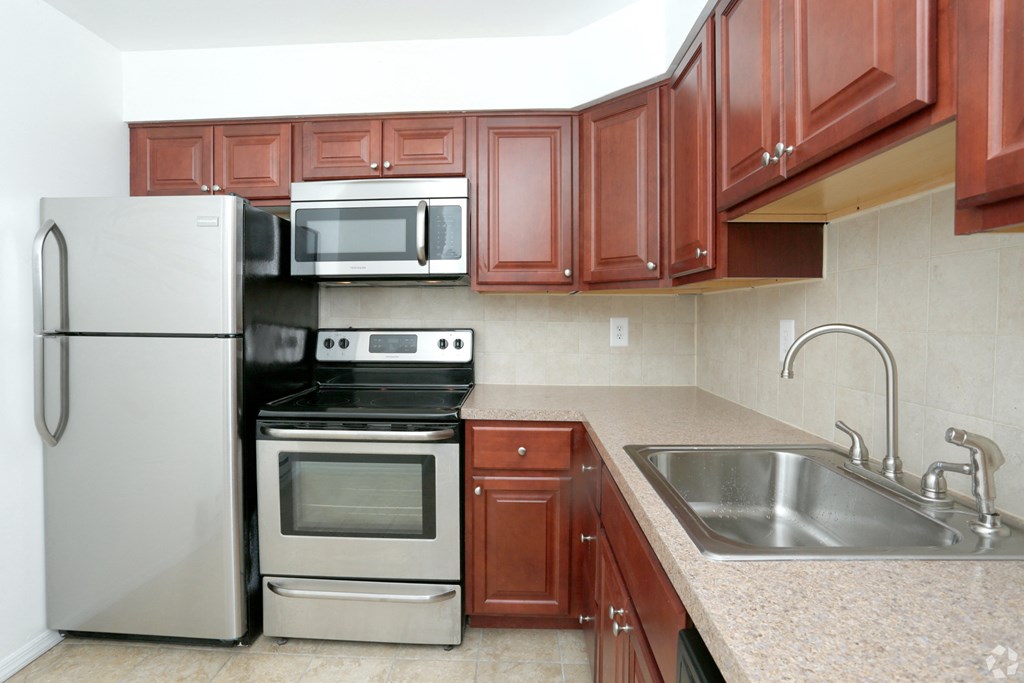 a kitchen with cherry cabinets and stainless steel appliances