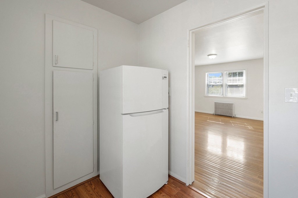 an empty room with a refrigerator and a door