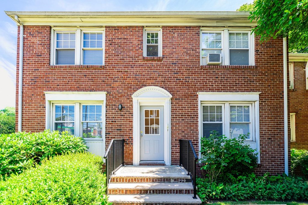 the front of a brick house with a white door