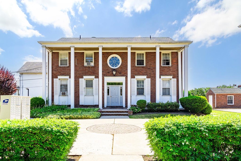 the front of a brick building with a clock on it