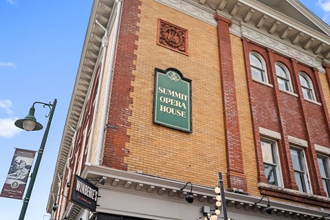 The Summit Opera House is a red brick building with a green sign on the front.