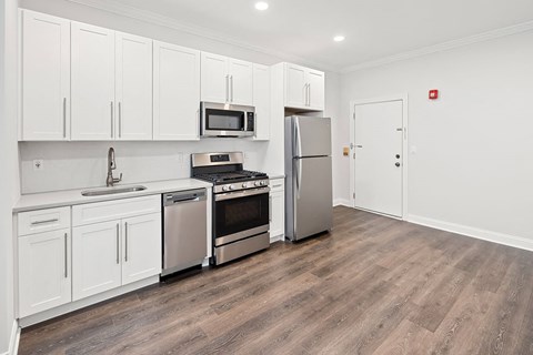 A kitchen with white cabinets and stainless steel appliances.