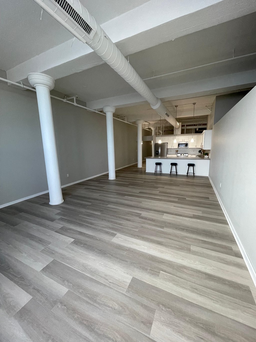 a room with a kitchen and a wood floor