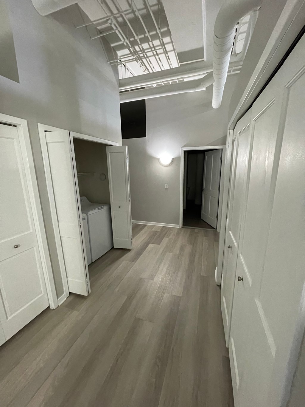 a room with white walls and wood floors and a closet