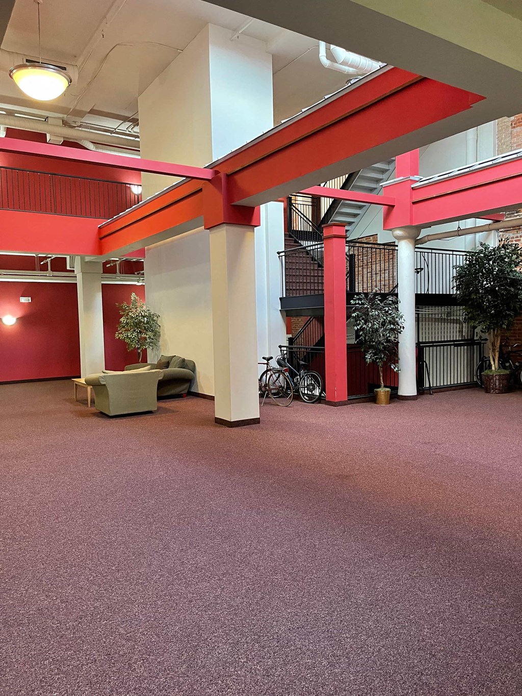 the lobby of an office building with red pillars and a pink carpet