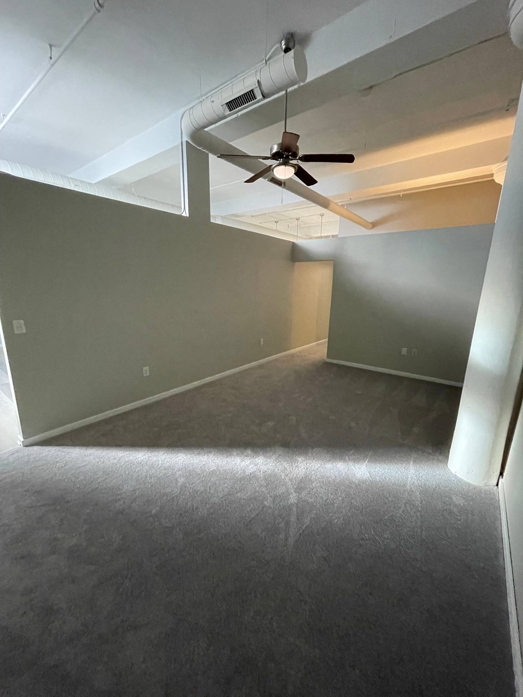 a living room with a ceiling fan and a green wall