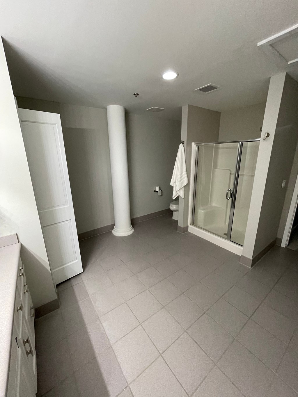 a bathroom with a shower and a sink and a white towel