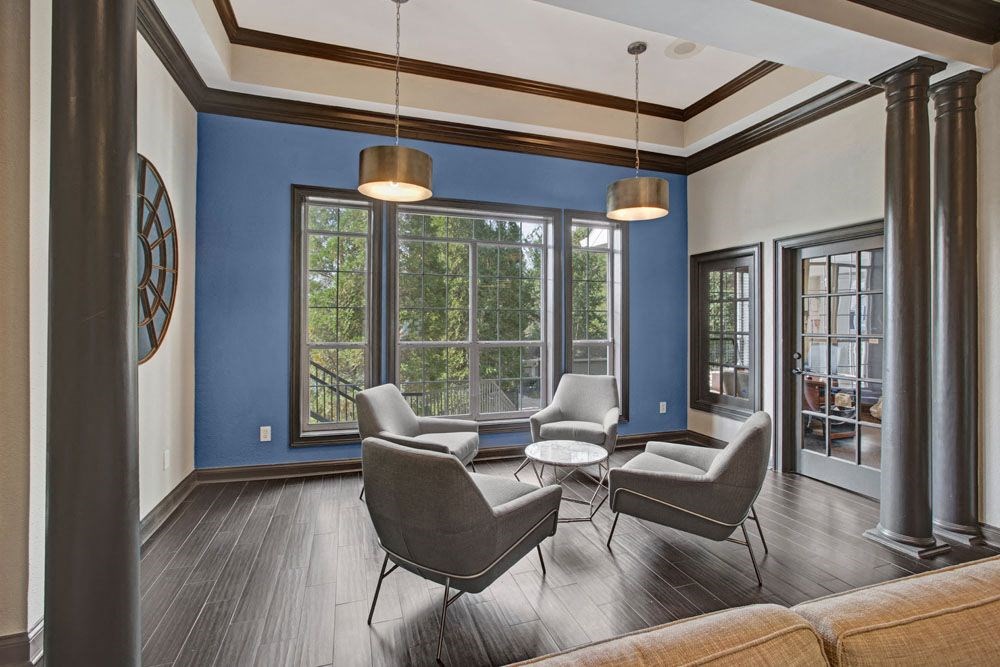 a living room with chairs and a large window