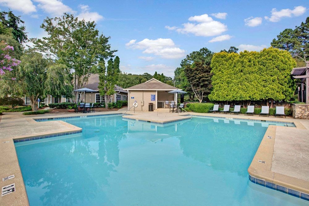 a large swimming pool with a house in the background