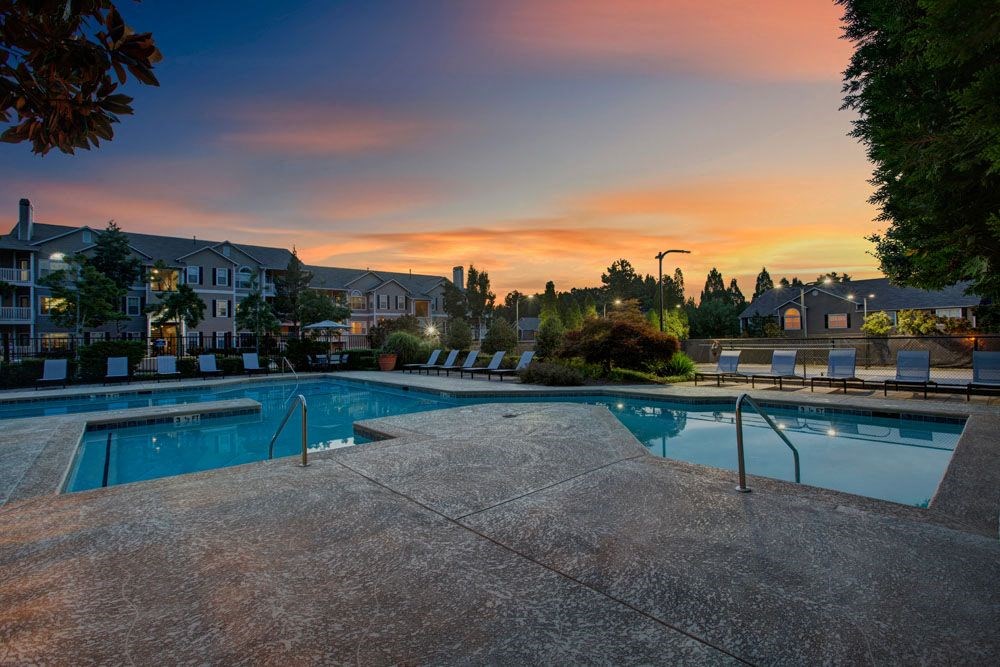 a swimming pool with a sunset in the background