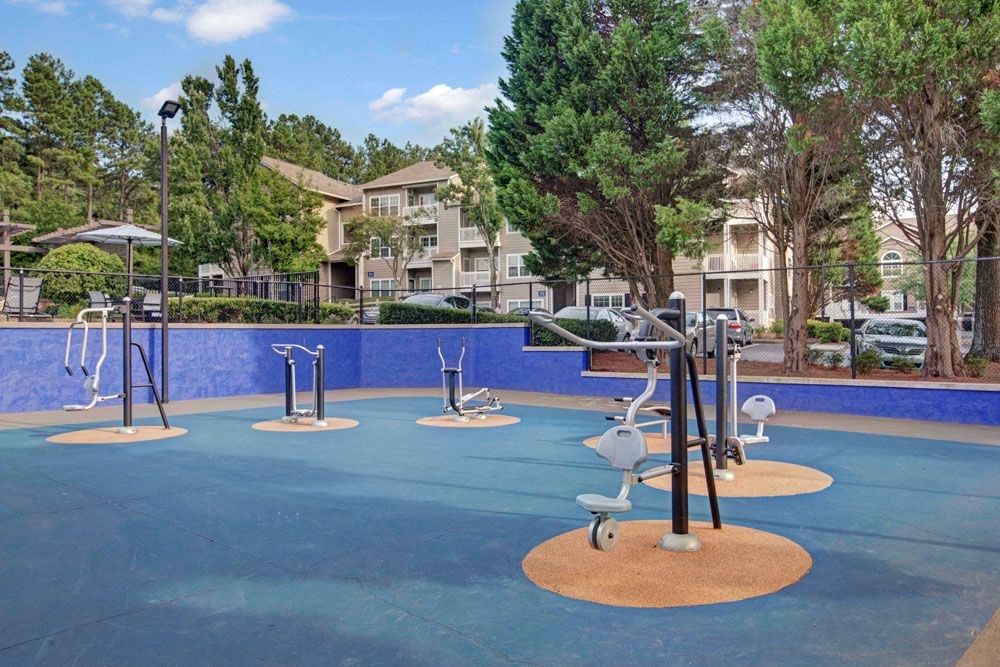 an empty playground at an apartment complex with swings and ropes