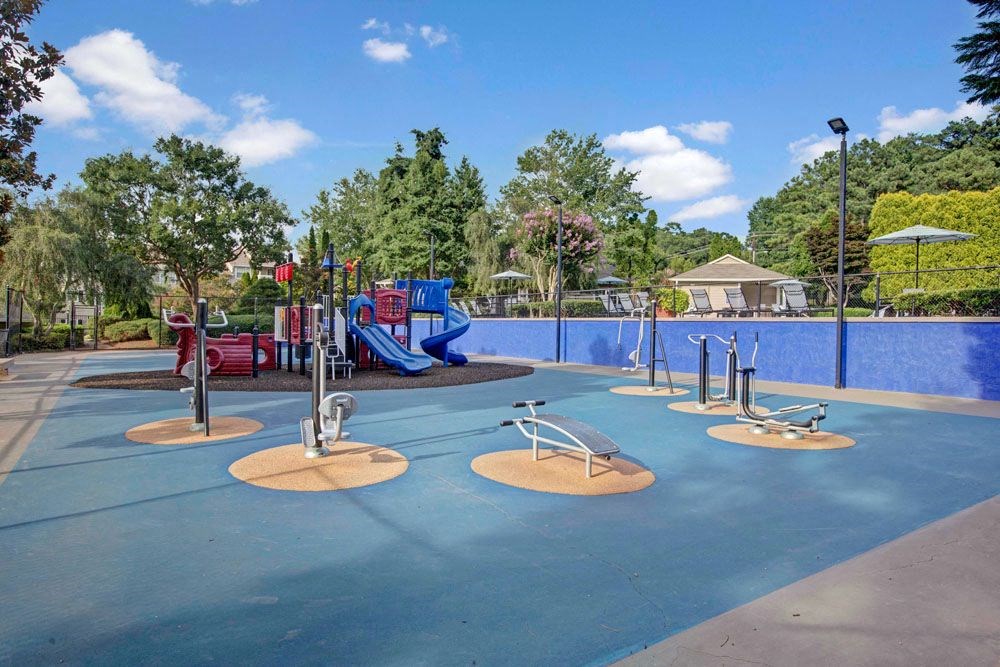 a playground with a blue pool and a bunch of playground equipment