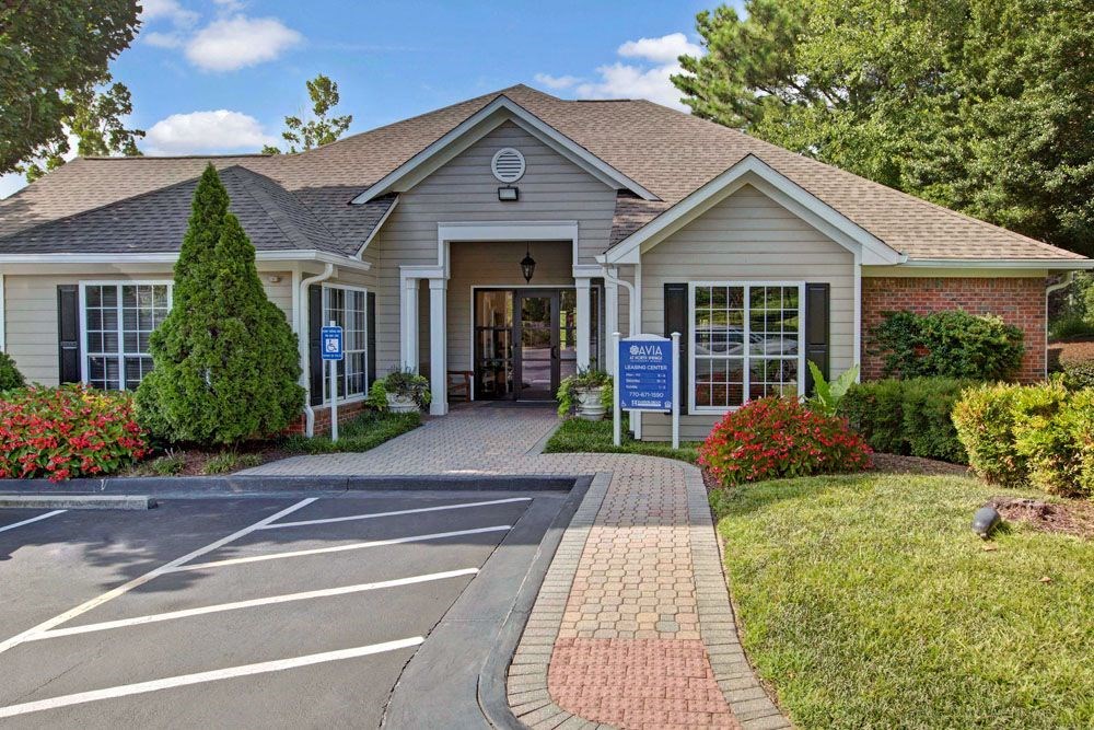 the front of a white house with a drive way and a porch