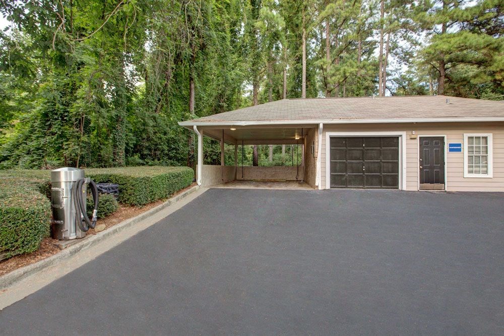 a driveway with a garage door in front of a house