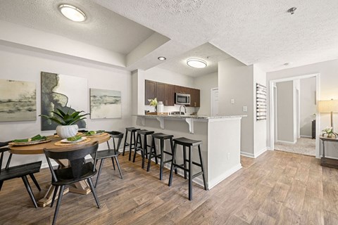 an open kitchen and dining area with a bar and a living room