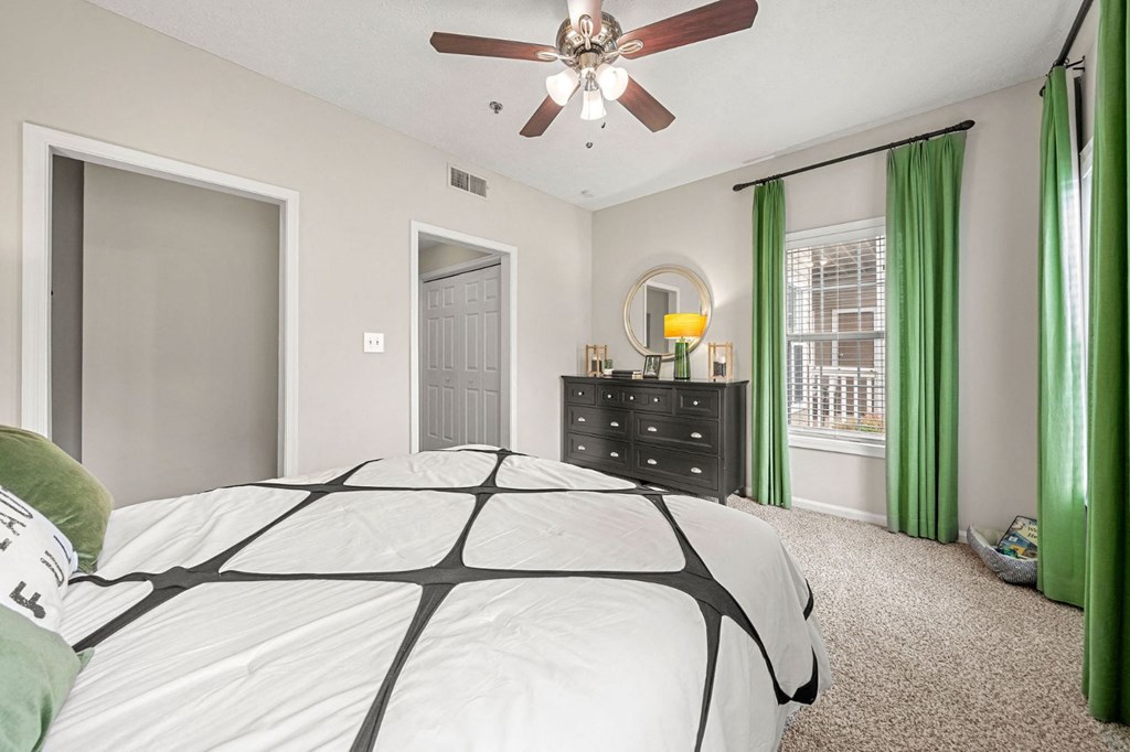 a bedroom with a large bed and a ceiling fan