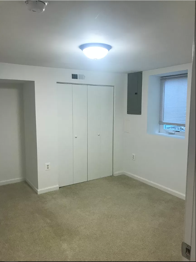 a room with white walls and a window and a ceiling light