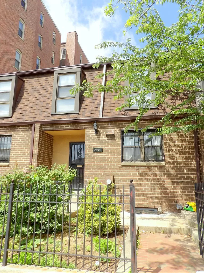 a brick house with a metal fence in front of it