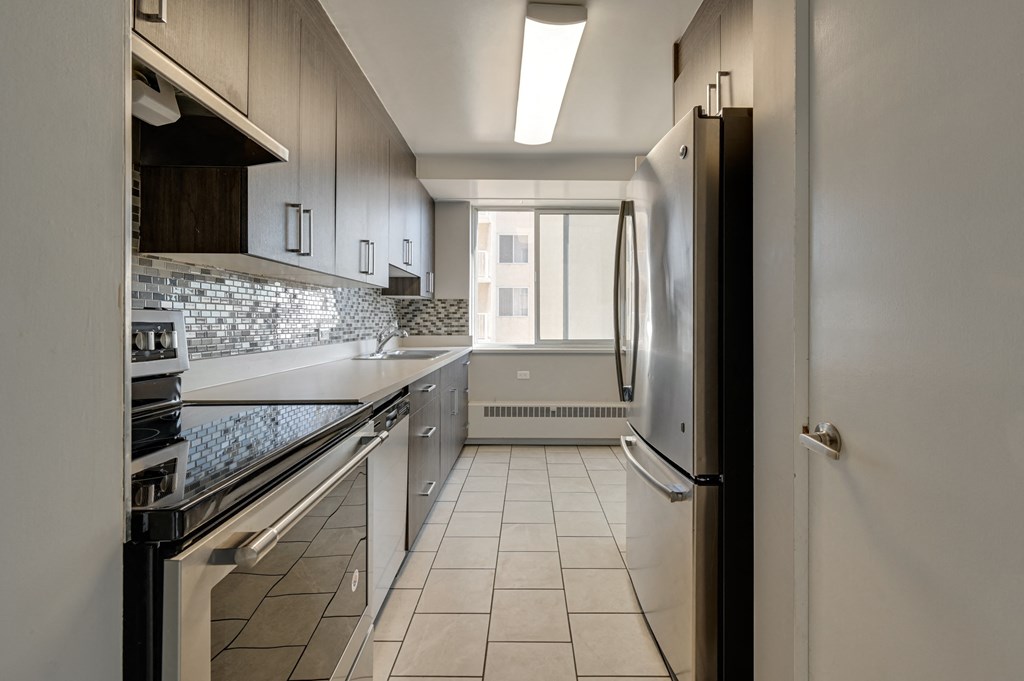 a kitchen with white cabinets and a stainless steel refrigerator