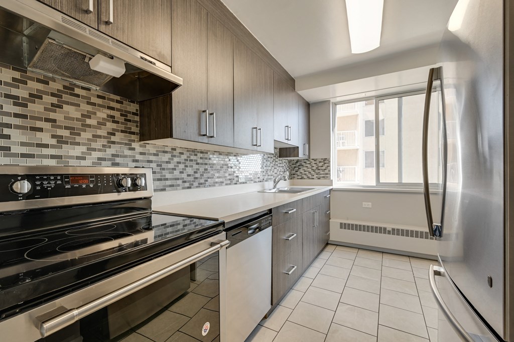 a kitchen with stainless steel appliances and white counter tops