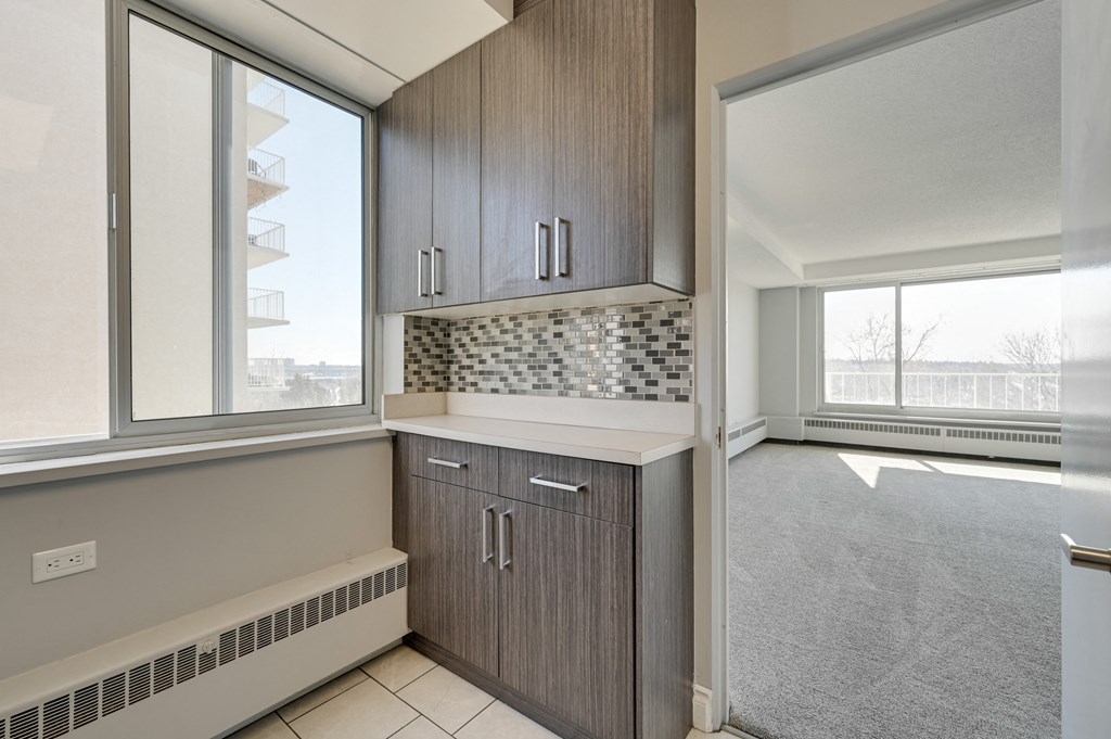 an empty kitchen with wood cabinets and a window