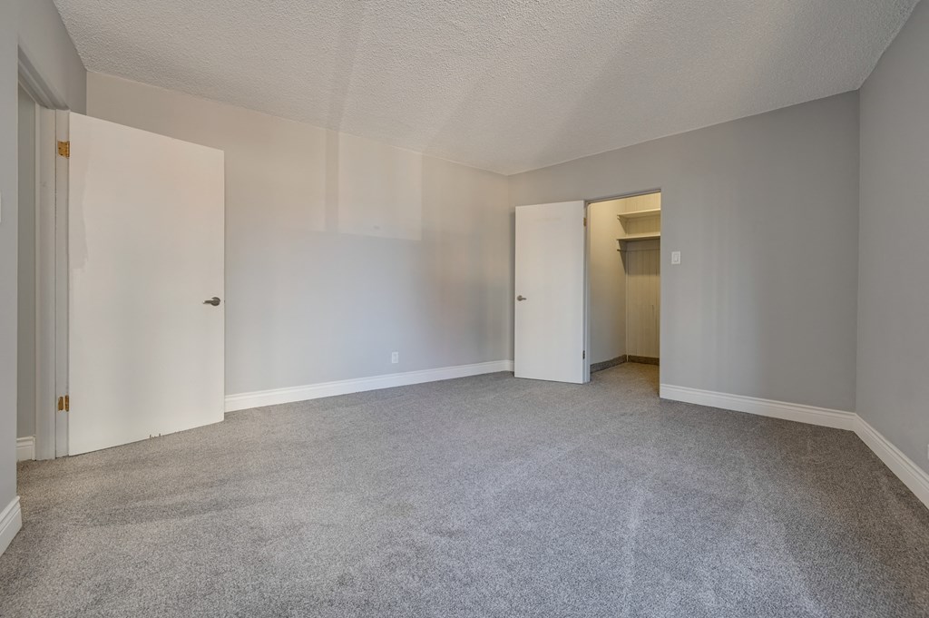 an empty living room with white walls and carpet