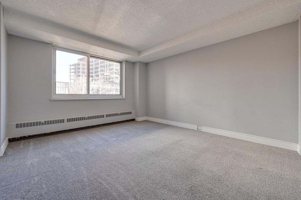 the living room of an empty apartment with a large window