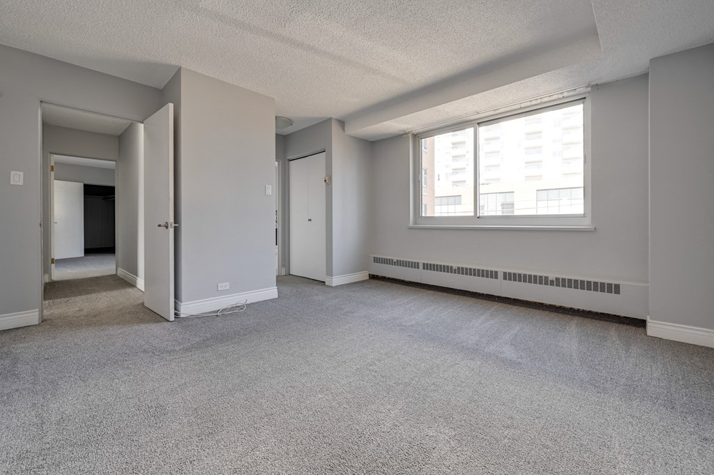 the living room of an empty apartment with a large window