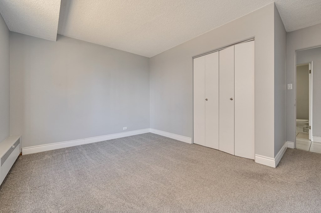 an empty living room with white walls and a closet