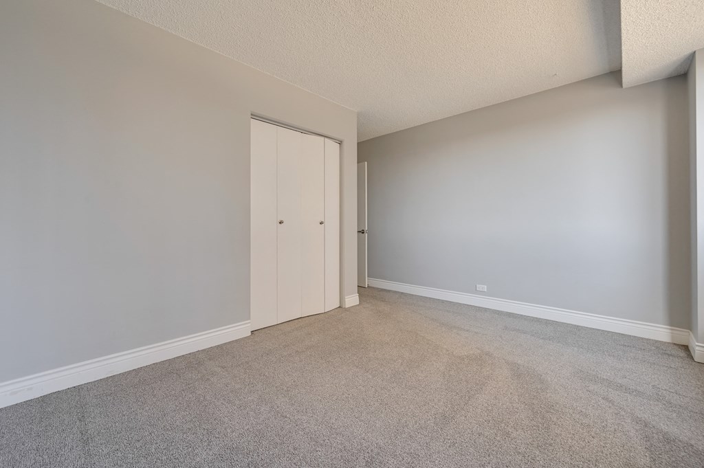an empty living room with a door to a closet