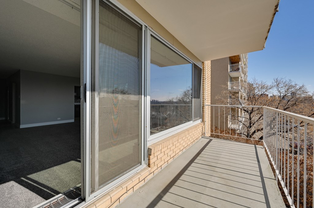 a balcony with large windows and a wooden deck