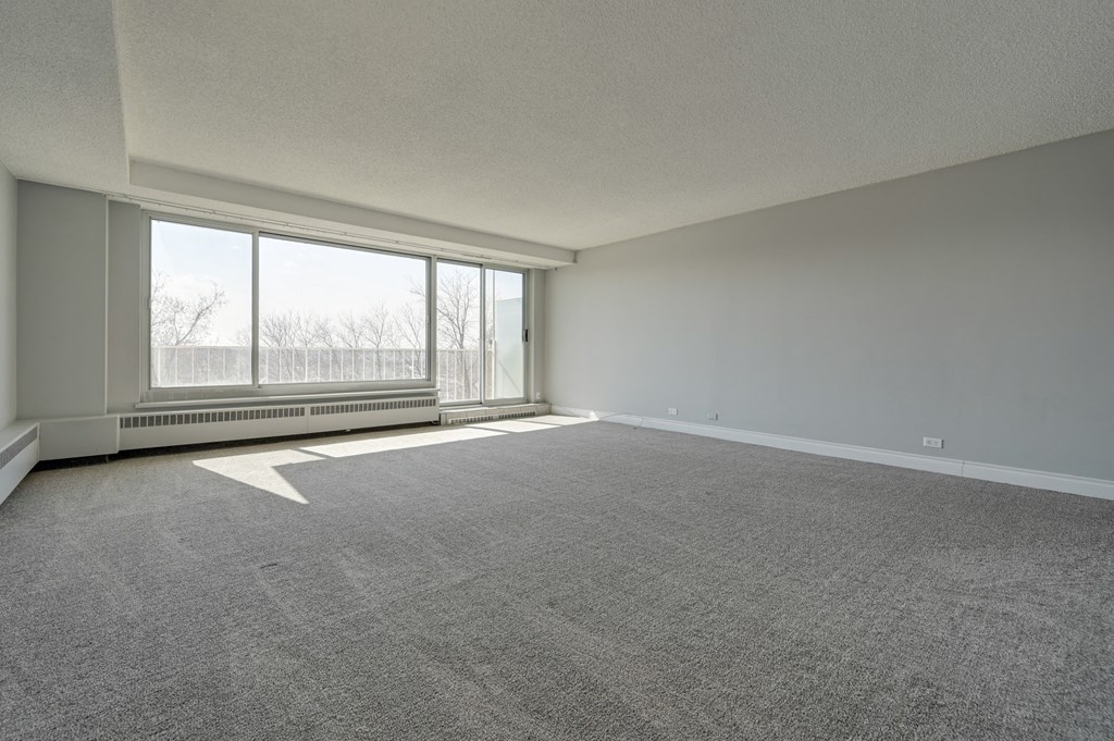 the living room of an empty apartment with a large window