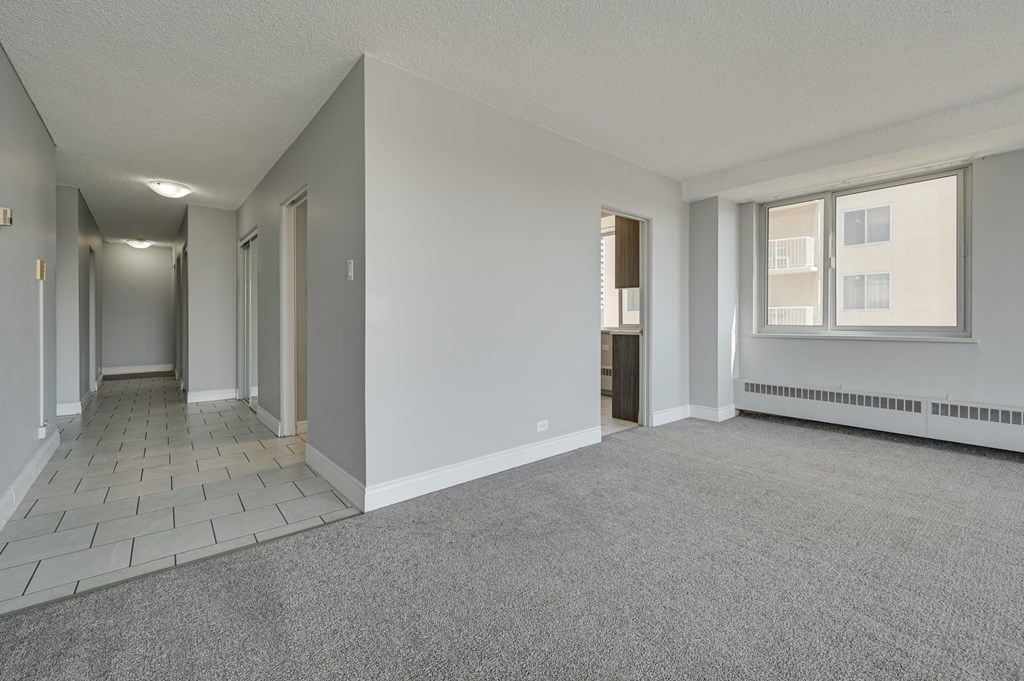 the living room and dining room of an empty apartment