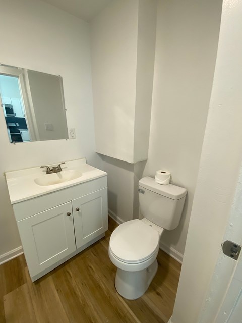 A white toilet sits next to a sink in a small bathroom.