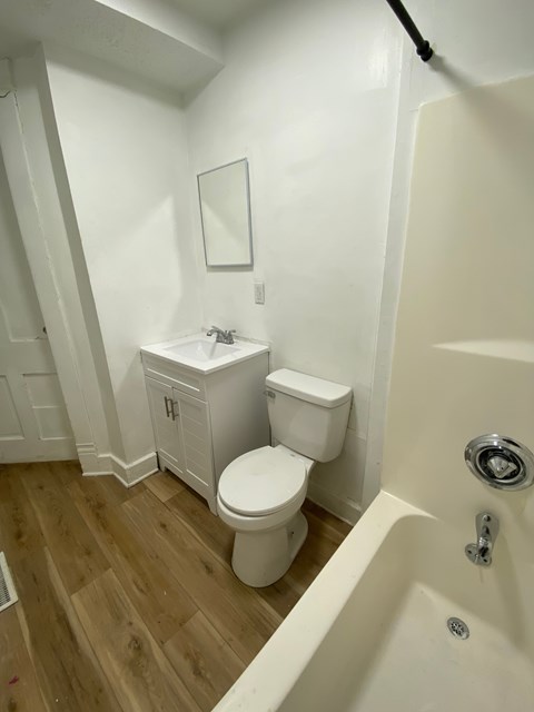 A white toilet and sink in a small bathroom.