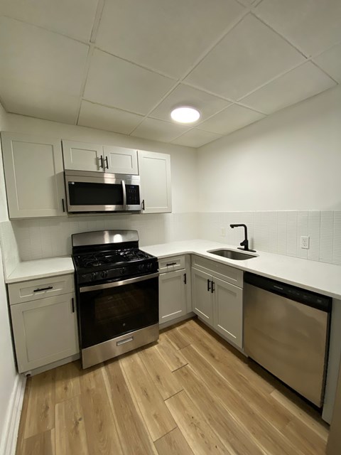 A kitchen with a stove, oven, and microwave.