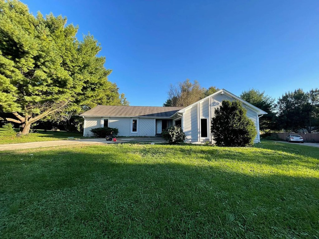 a white house with a yard and a tree