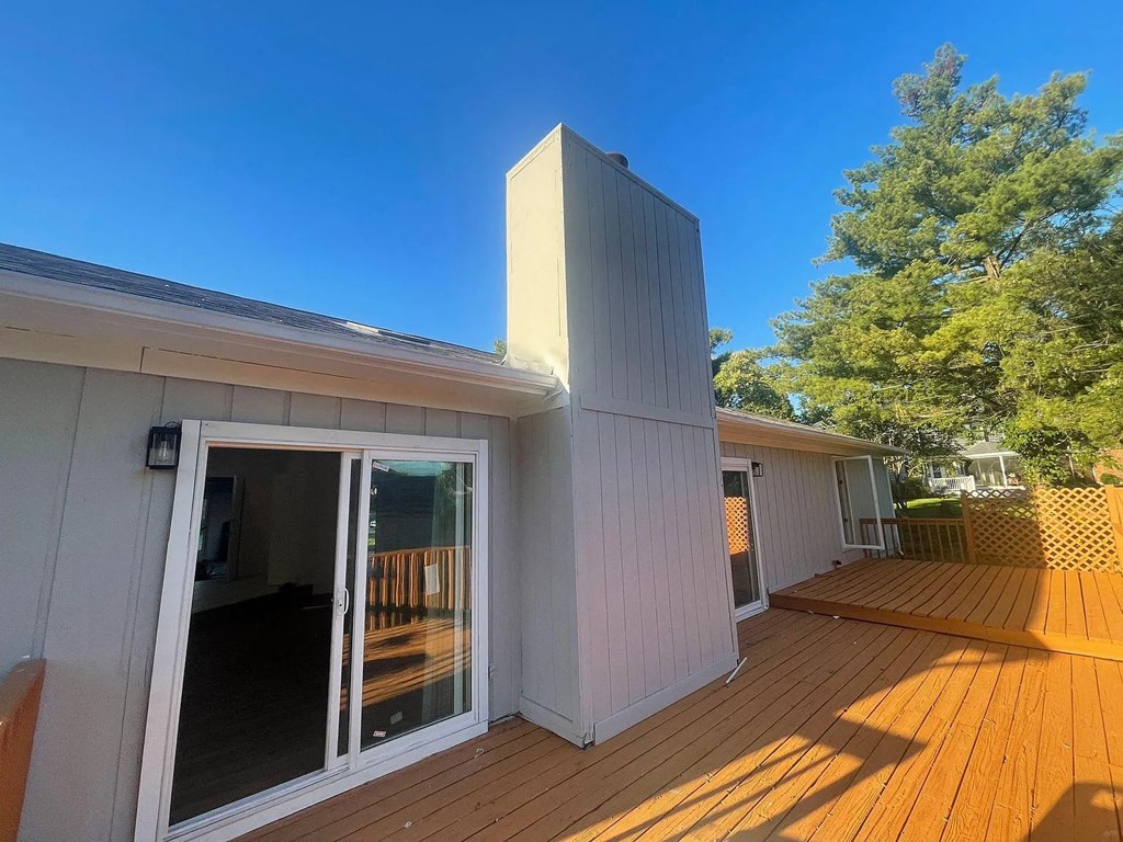 a view of the back of a house with a wooden deck