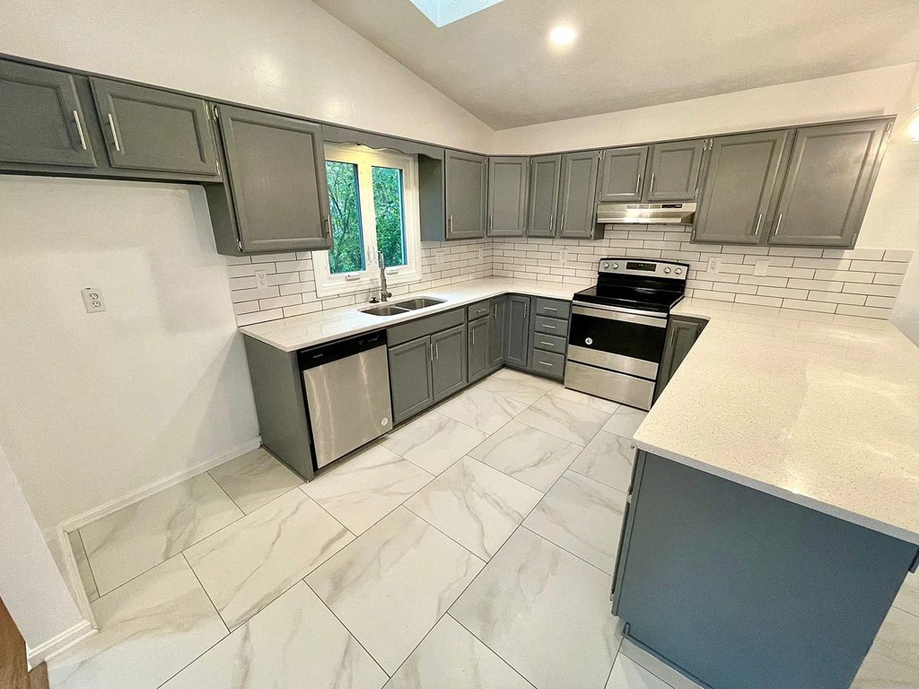 a kitchen with stainless steel appliances and gray cabinets