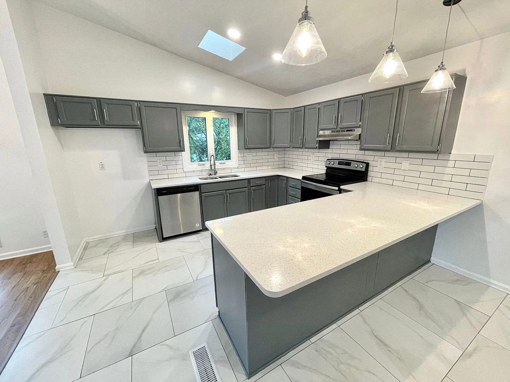 a kitchen with gray cabinets and a white counter top
